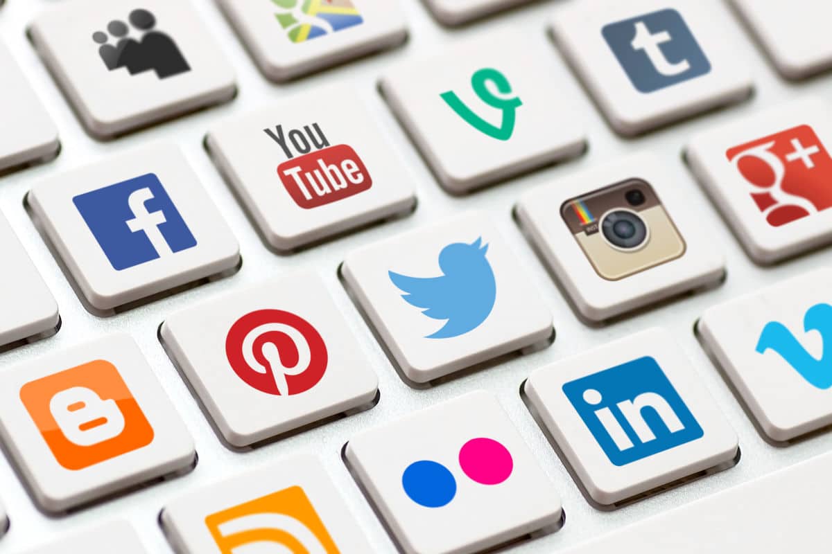 Man sieht eine Tastatur mit verschiedenen Social Media Symbolen. Diese Kanäle kann man mit einem Social Media Tool verwalten.